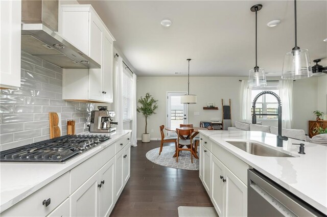 5025 Bryce Ln, Cumming, GA 30040 - kitchen featuring wall chimney exhaust hood, stainless steel appliances, a sink, white cabinetry, and backsplash