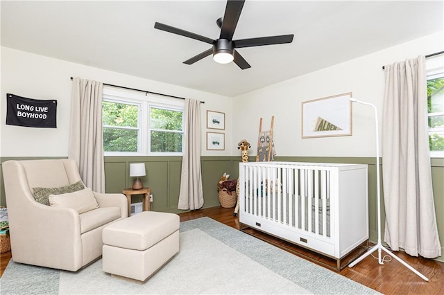 1329 W Nancy Creek Dr NE, Brookhaven, GA 30319 - bedroom featuring multiple windows, wood finished floors, a crib, and ceiling fan