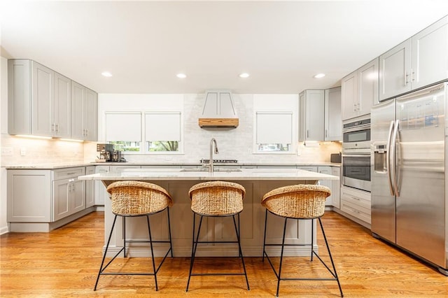 1329 W Nancy Creek Dr NE, Brookhaven, GA 30319 - kitchen featuring appliances with stainless steel finishes, tasteful backsplash, a kitchen island with sink, a kitchen bar, and recessed lighting