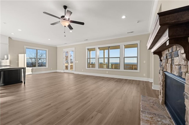 unfurnished living room featuring ceiling fan, light hardwood / wood-style flooring, ornamental molding, and a fireplace