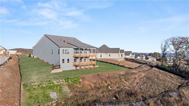 rear view of house with a lawn and a wooden deck