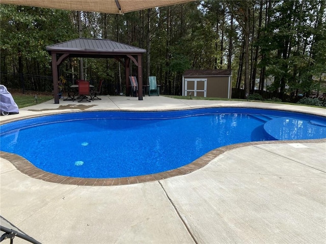 outdoor pool with fence, a gazebo, an outdoor structure, a patio area, and a storage unit