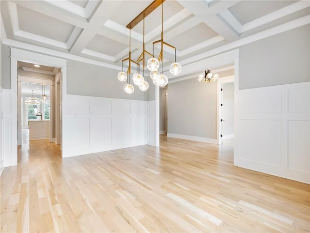 empty room with coffered ceiling, beam ceiling, ornamental molding, and light wood-type flooring