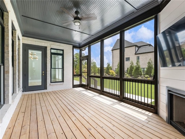 unfurnished sunroom featuring ceiling fan