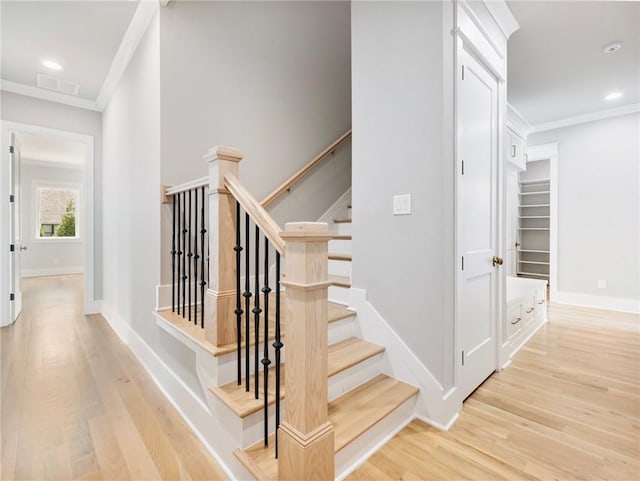 stairway featuring ornamental molding and hardwood / wood-style floors