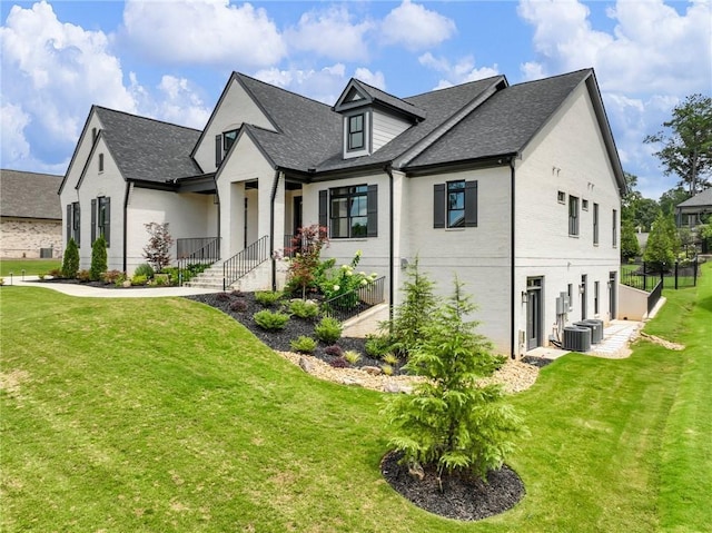 view of front of home with central AC and a front lawn