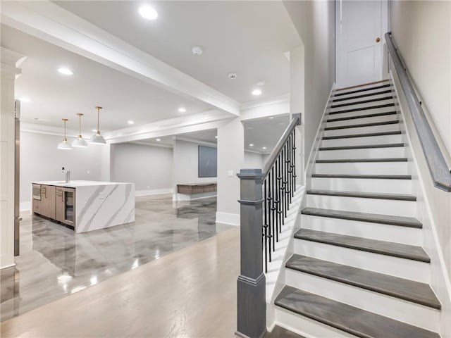 stairway with crown molding, wet bar, and wine cooler