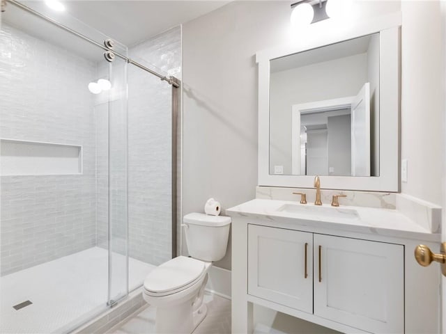 bathroom with vanity, tile patterned flooring, toilet, and walk in shower