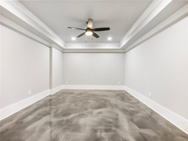 empty room with a tray ceiling, ornamental molding, concrete floors, and ceiling fan