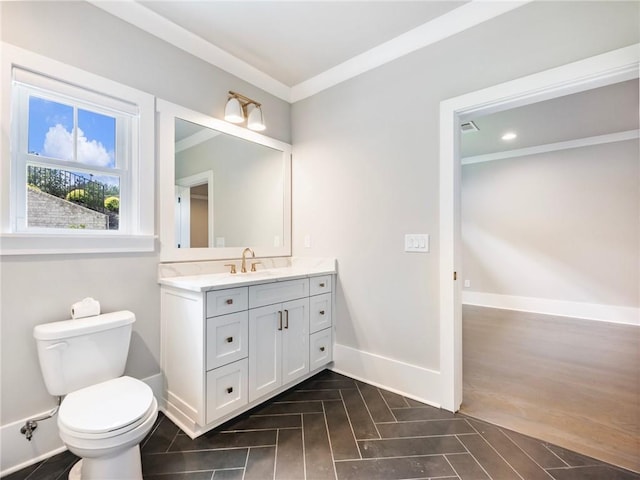 bathroom with vanity, ornamental molding, and toilet