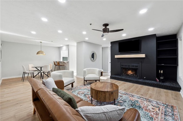 living room featuring ceiling fan and light hardwood / wood-style floors