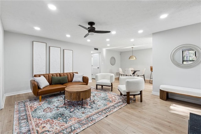 living room featuring ceiling fan and light wood-type flooring