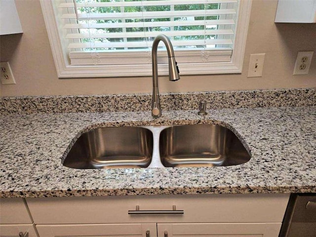 interior details featuring light stone countertops and a sink