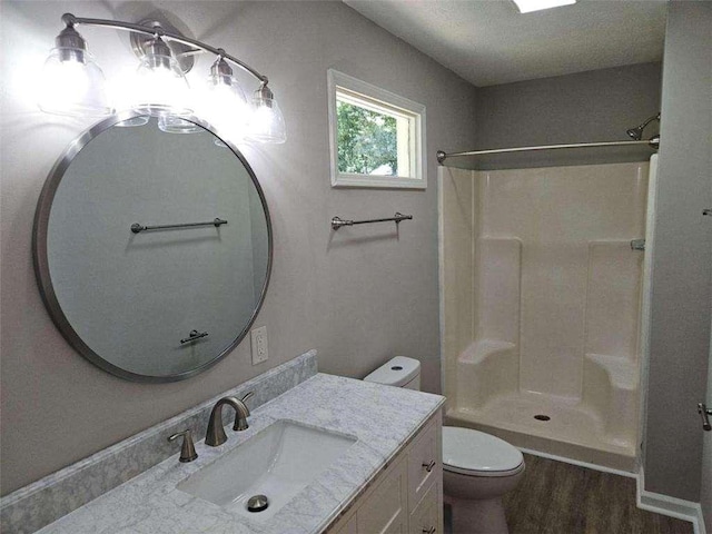 full bath featuring a shower, toilet, wood finished floors, and vanity