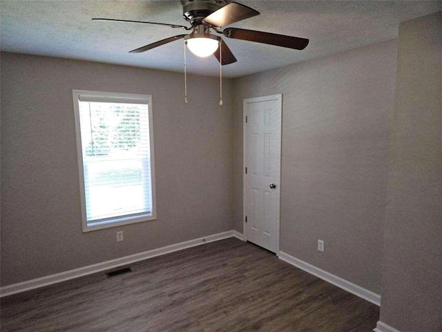 unfurnished room featuring visible vents, baseboards, wood finished floors, a textured ceiling, and a ceiling fan