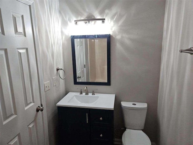 bathroom featuring toilet and vanity