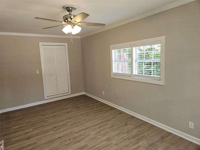 unfurnished room with crown molding, wood finished floors, a ceiling fan, and baseboards