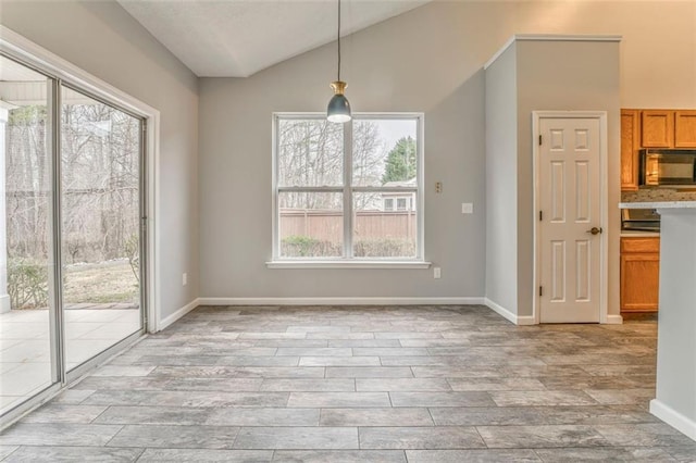 unfurnished dining area featuring light hardwood / wood-style flooring and lofted ceiling