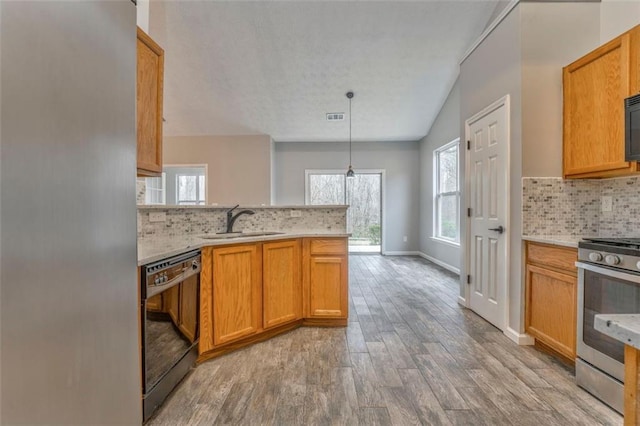 kitchen featuring black appliances, tasteful backsplash, sink, hanging light fixtures, and vaulted ceiling