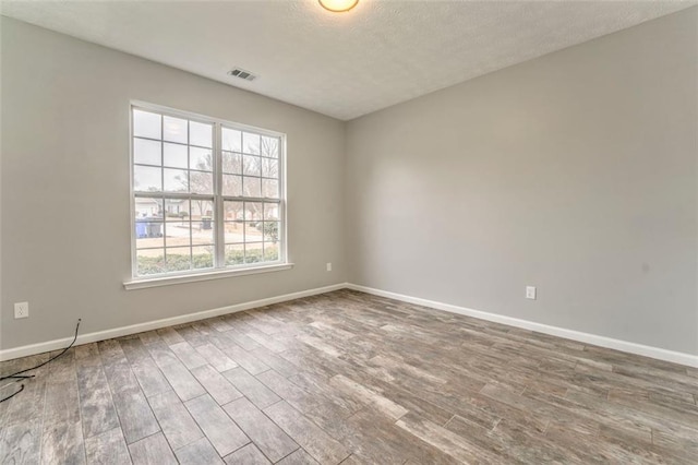 unfurnished room featuring hardwood / wood-style floors and a textured ceiling