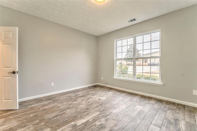 unfurnished room with hardwood / wood-style flooring