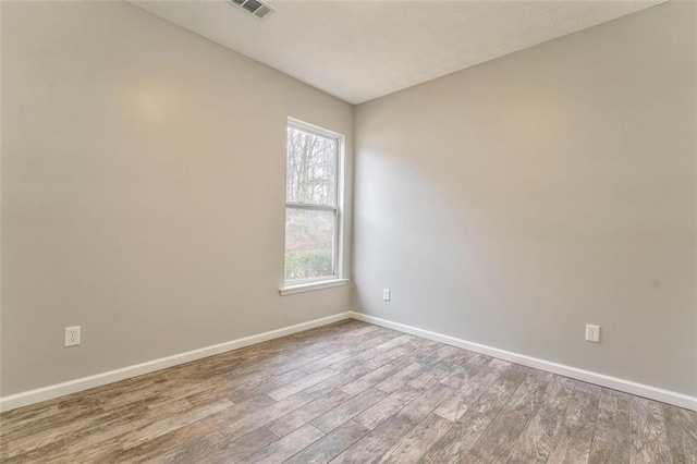 spare room with hardwood / wood-style flooring and a healthy amount of sunlight