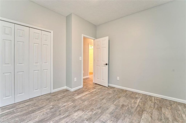 unfurnished bedroom featuring a closet, hardwood / wood-style floors, and a textured ceiling