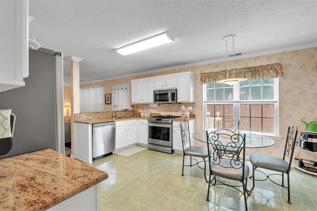 3573 Willow Tree Trce, Decatur, GA 30034 - kitchen featuring appliances with stainless steel finishes, wallpapered walls, a textured ceiling, white cabinetry, and a sink