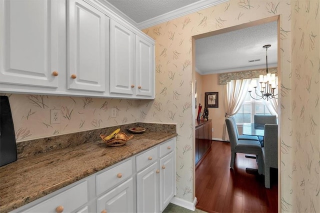 3573 Willow Tree Trce, Decatur, GA 30034 - kitchen with a textured ceiling, crown molding, a chandelier, white cabinets, and wallpapered walls