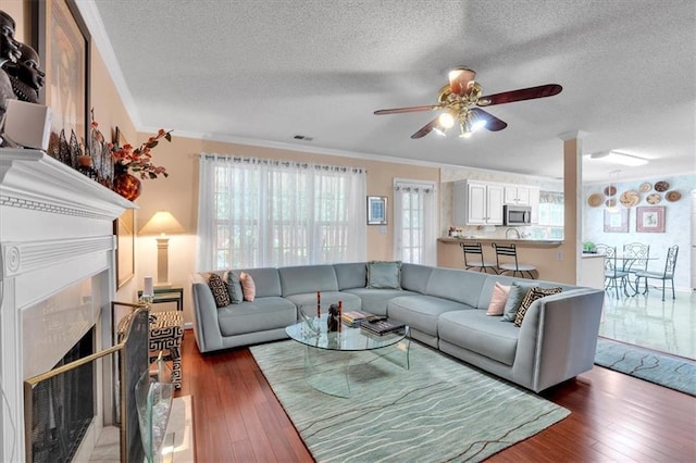 3573 Willow Tree Trce, Decatur, GA 30034 - living area with ornamental molding, a ceiling fan, a textured ceiling, wood-type flooring, and a fireplace
