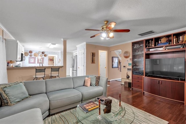 3573 Willow Tree Trce, Decatur, GA 30034 - living room featuring a ceiling fan, dark wood-type flooring, a textured ceiling, and crown molding