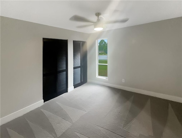 carpeted spare room featuring ceiling fan