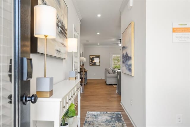 hallway featuring hardwood / wood-style floors and crown molding