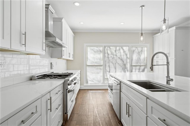 kitchen featuring crown molding, appliances with stainless steel finishes, wall chimney range hood, and white cabinets