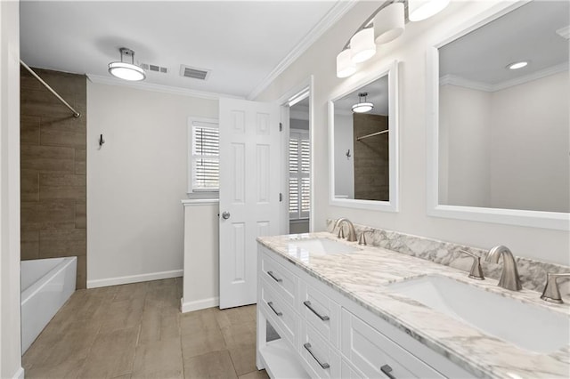 bathroom featuring tiled shower / bath combo, vanity, and crown molding