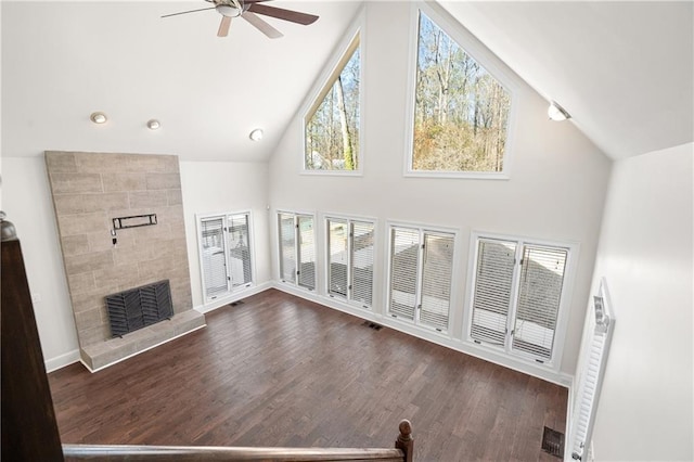 unfurnished living room featuring dark hardwood / wood-style flooring, a fireplace, and high vaulted ceiling