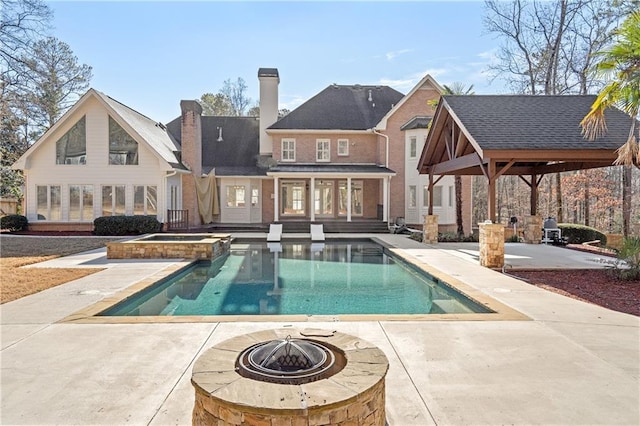 rear view of house featuring a gazebo, a patio area, and an outdoor fire pit