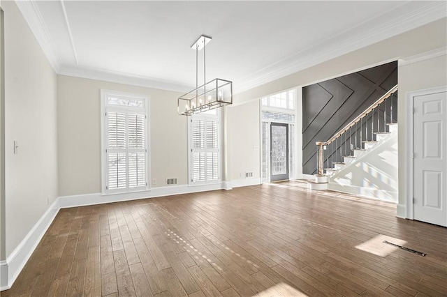 unfurnished living room featuring hardwood / wood-style floors, a notable chandelier, and ornamental molding