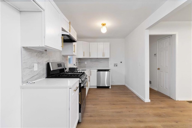 1894 Evans Dr SW, Atlanta, GA 30310 - kitchen with light countertops, white cabinets, light wood-style floors, under cabinet range hood, and appliances with stainless steel finishes
