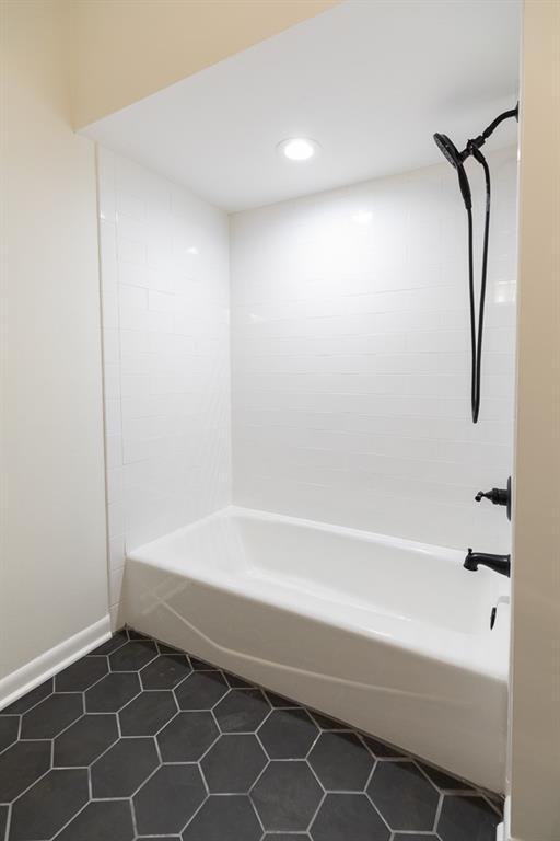 bathroom featuring tiled shower / bath and tile flooring