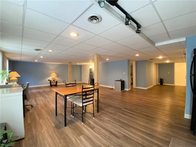 dining area featuring a paneled ceiling and dark hardwood / wood-style flooring