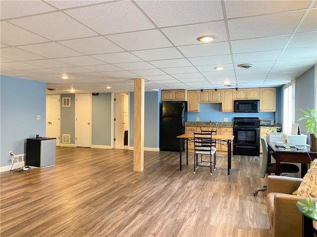 dining space featuring a drop ceiling and light wood-type flooring