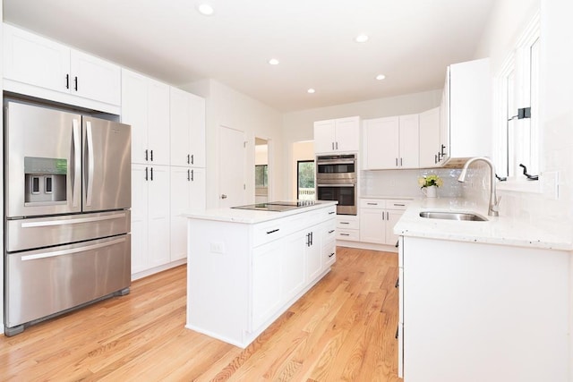 kitchen featuring light hardwood / wood-style flooring, sink, appliances with stainless steel finishes, and a center island