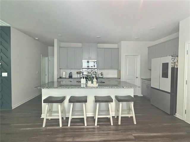 283 Wells Cir, Canton, GA 30114 - kitchen featuring stainless steel microwave, refrigerator, stone countertops, and a kitchen bar