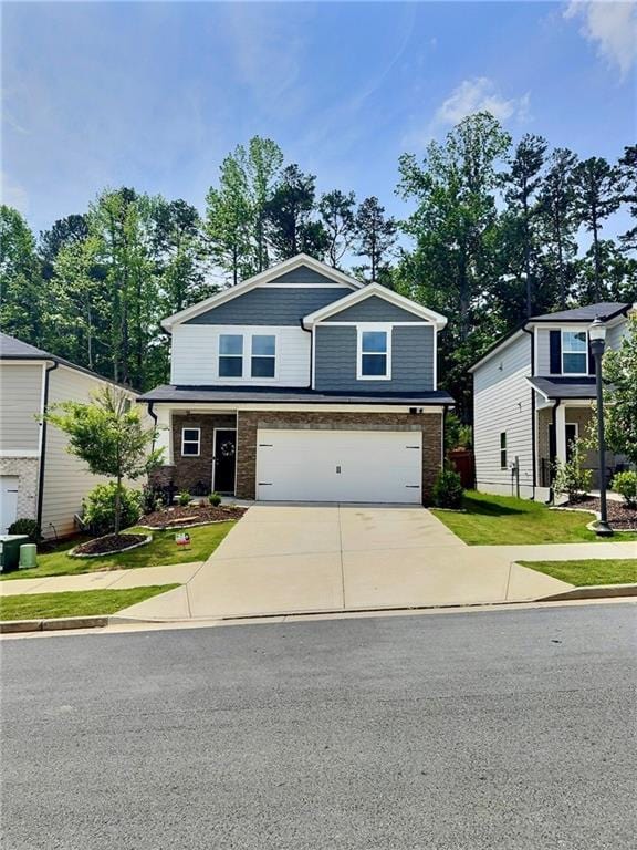 283 Wells Cir, Canton, GA 30114 - view of front of home with concrete driveway, a garage, brick siding, and a front lawn