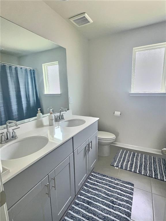 283 Wells Cir, Canton, GA 30114 - bathroom with double vanity, toilet, and tile patterned floors