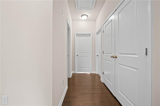 corridor with dark wood-type flooring and baseboards