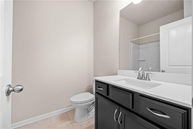 bathroom with baseboards, a shower, toilet, tile patterned floors, and vanity