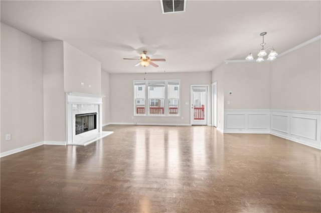 unfurnished living room featuring a decorative wall, ceiling fan with notable chandelier, dark wood-style flooring, a high end fireplace, and visible vents