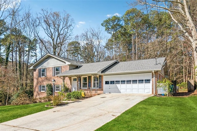 tri-level home featuring driveway, brick siding, an attached garage, and a front yard